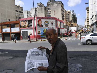 Un hombre lee un periódico, ayer en una calle de Caracas.