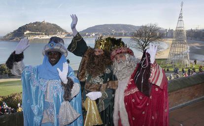 Los Reyes Magos saludan a los niños tras llegar a San Sebastián para la cabalgata de la capital guipuzcoana.