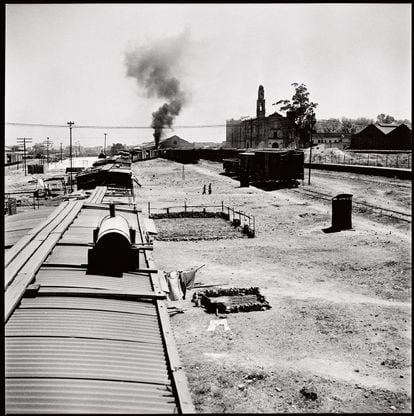 El humo de la chimenea de una locomotora, con la iglesia de Santiago Tlateloco a la derecha.