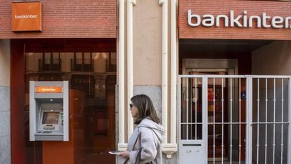 Una mujer pasa por delante de una oficina de Bankinter.