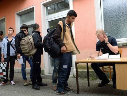 Un policía alemán registra a un grupo de demandantes de asilo en la estación de Freilassing, en el sur de Alemania, el pasado 15 de junio.
