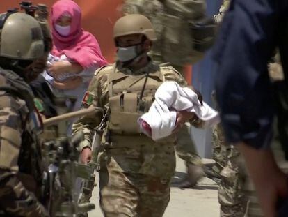 Un agente traslada a un bebé del hospital de Dasht e Barchi, en Kabul, tras el ataque del pasado 12 de mayo.