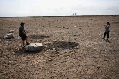 Unos curiosos fotografían un bloque de cemento arrancado desde la plataforma de SpaceX en Boca Chica, Texas.