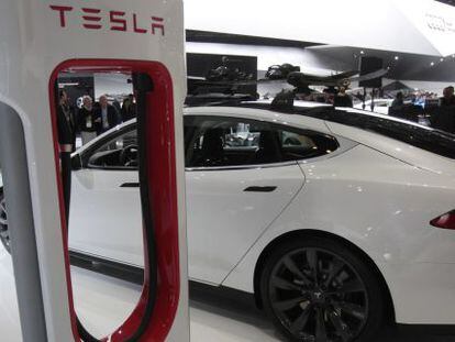 Un Tesla Model S junto a su cargador