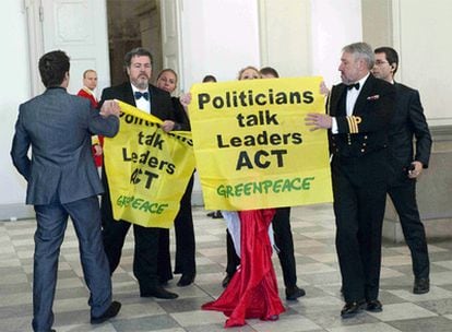 El director ejecutivo de Greenpeace España, Juan López de Uralde, porta una pancarta de protesta en la cena de gala de los Jefes de Estado y de Gobierno de la Cumbre del Clima