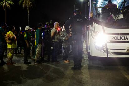 Partidarios detenidos del expresidente brasileño Jair Bolsonaro suben a un autobús para ser llevados a una comisaría tras los enfentamientos.