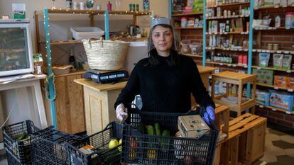 Sara Giacalone sujeta una cesta de un pedido a domicilio en su tienda de productos ecológicos Cocómero,  en Madrid.