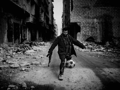 Islamista juega al fútbol entre las ruinas de Alepo (Siria), en 2013.
