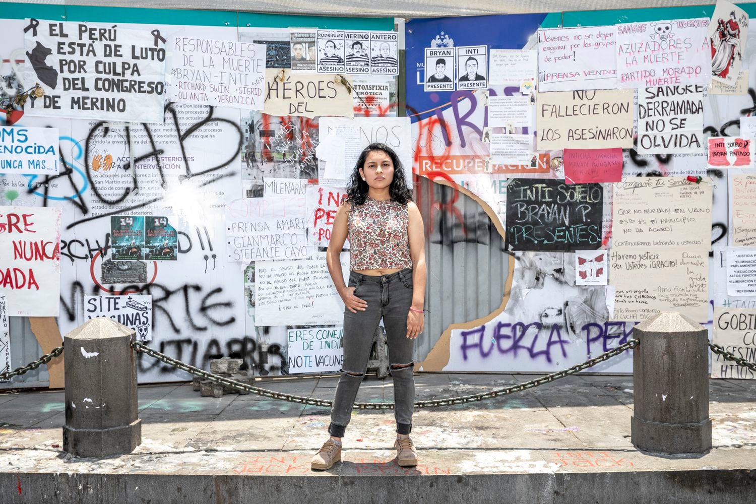 La estudiante de periodismo Alba Ñaupas posa frente a un muro con las consignas de las manifestaciones en Lima.
