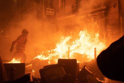 Un bombero intenta extinguir un incendio en una calle de París, este jueves.