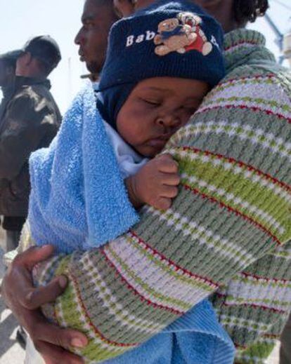 Un bebé en brazos de su madre tras su llegada a las costas de Motril (Granada).