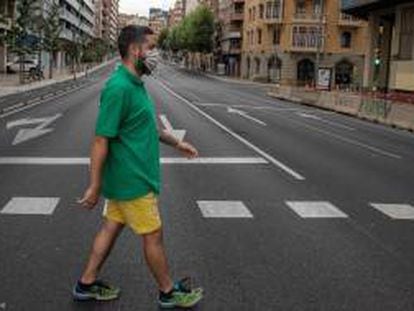 Un vecino cruza la calle en una avenida de Catalunya prácticamente vacía.
