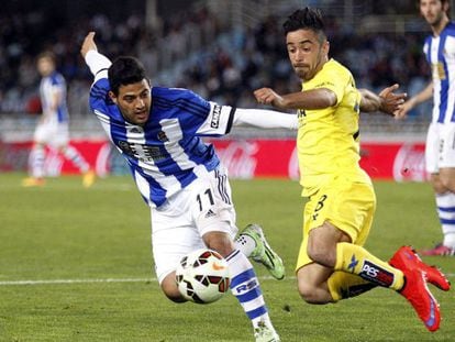 El delantero mexicano de la Real Sociedad Carlos Vela lucha un bal&oacute;n con J. Costa, del Villarreal.