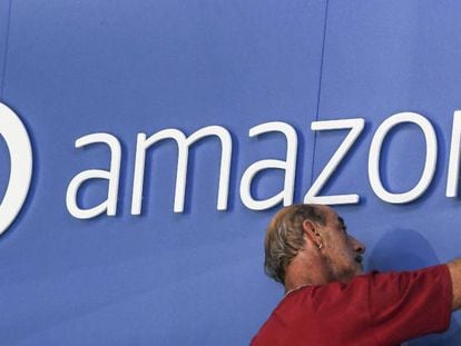 Un hombre ajusta un logotipo de Amazon.