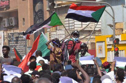 Manifestantes sudaneses ondean banderas nacionales en una marcha de apoyo al Gobierno civil, en Jartum este jueves.