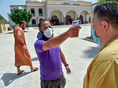 Un voluntario toma la temperatura a un hombre a la entrada de una mezquita en Argel, el 15 de agosto.