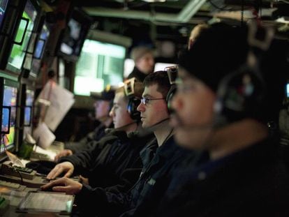Marineros estadounidenses delante de pantallas del sónar de un submarino.
