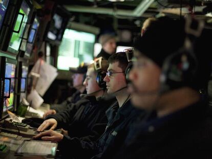 Marineros estadounidenses delante de pantallas del sónar de un submarino.