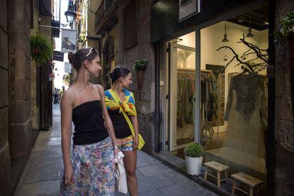 Dos jóvenes miran un escaparate de la barcelonesa calle Falssaders.