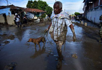 Un hombre camina con un perro después de una avalancha del río La Paila, en el municipio de Corinto, departamento del Cauca (Colombia).