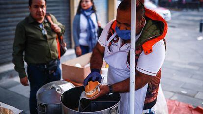 Un comerciante prepara una torta de tamal en la Colonia Roma en Ciudad de México. 