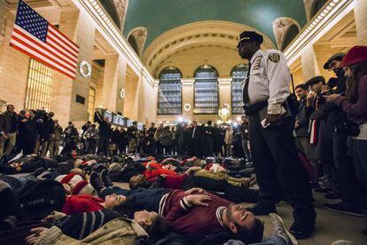 Desenes d'activistes s'han tombat al vestíbul de l'Estació Central de Nova York per protestar per la resolució judicial que deixa lliure el policia que va escanyar Eric Garner, un home negre de 43 anys.