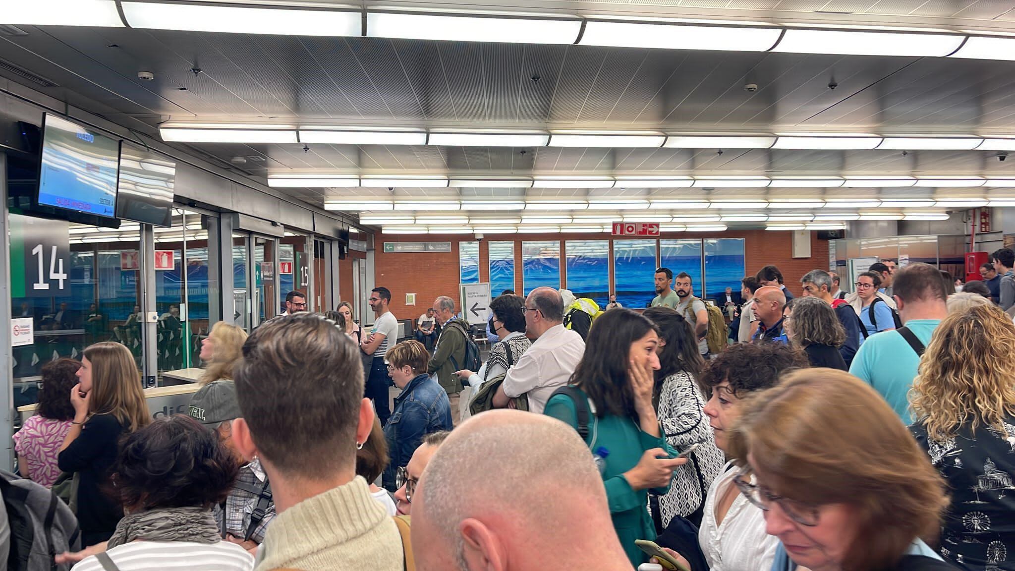 Varios usuarios de Renfe esperan al tren, que llega con retraso, en Atocha, Madrid.