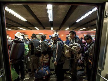 Migrantes recorren los pasillo del metro.