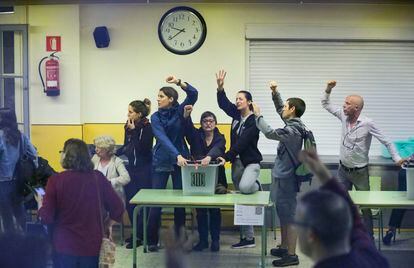 Participantes en el referéndum ilegal del 1-O se aferran a una urna antes de la entrada de la policía en la escuela Ramón Llull de Barcelona.