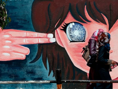 Dos mujeres palestinas pasan frente a un grafiti en una pared de la escuela de las Naciones Unidas de Beit Hanun, en el norte de la Franja de Gaza, en 2016.