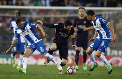 Lionel Messi (centro) presionado por Javi Fuego (d) y Pablo Piatti.