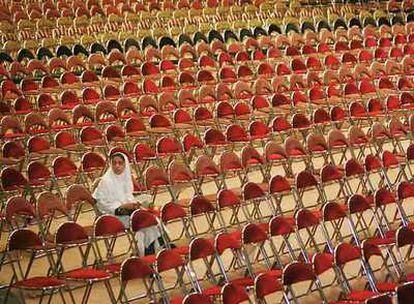 Una estudiante iraní espera en una boda multitudinaria financiada por organizaciones para ayudar a los que no se pueden costear la ceremonia.