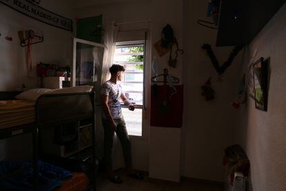 Omar Kordala mira por la ventana de su habitación en el piso tutelado donde vive en el barrio de Usera en Madrid, en julio de 2021.