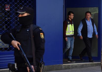 El presidente del Huesca, Agustín Lasaosa, junto a un policía a su salida de las oficinas del club tras ser detenido durante la "Operación Oikos" contra el presunto amaño de partidos de fútbol en Primera y Segunda División en 2019.