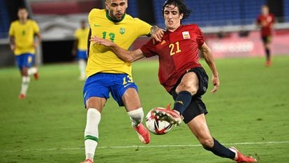 Brazil's Dani Alves (L) and Spain's Bryan Gil vie for the ball during the Tokyo 2020 Olympic Games football competition men's gold medal match at Yokohama International Stadium in Yokohama, Japan, on August 7, 2021. (Photo by Anne-Christine POUJOULAT / AFP)