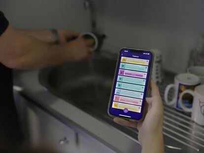 Una mujer usa la 'app' MeToca para gestionar el reparto de tareas del hogar.