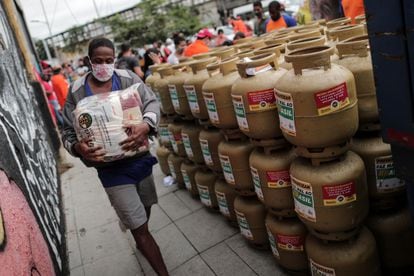 Un hombre lleva uno de los paquetes con alimentos que fueron entregados a un grupo de personas que compró gas a mitad de precio durante una campaña en 2021. La inflación ha disminuido el poder adquisitivo en Brasil.