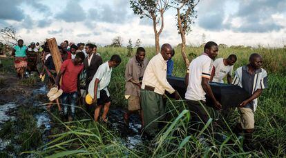 Un grupo de personas trasladan el cadáver de una persona fallecida en Mozambique.