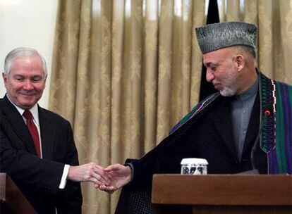 El secretario de Defensa de EE UU, Robert Gates, saluda al presidente afgano, Hamid Karzai, en Kabul.