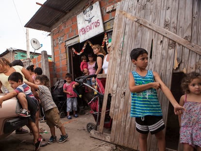 Niños juegan frente al comedor de beneficiencia Pekeñitos en el barrio Rafael Calzada de Buenos Aires.