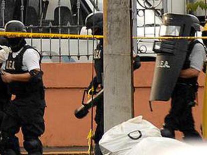 La policía de Costa Rica escolta al secuestrador, cubierto con un chubasquero (a la derecha), fuera de la sede diplomática rusa.
