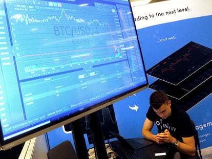 Un hombre muestra una pantalla con el precio del bitcoin durante un congreso en Nueva York, en 2018.