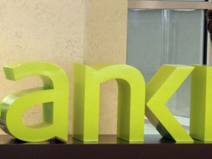 Una operaria limpia el logotipo de Bankia en la sede central de Bancaja