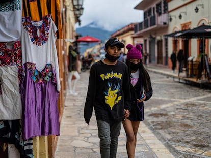 Dos jóvenes pasan frente a un puesto de artesanías en San Cristóbal de las Casas, Chiapas.