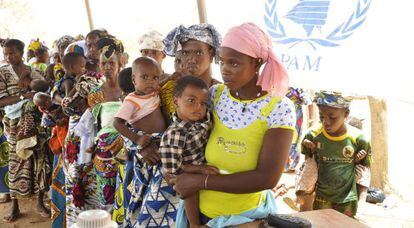 Mujeres y niños hacen cola en un campamento de Burkina Faso.