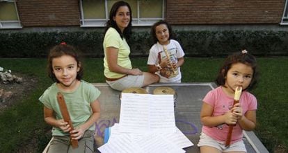 Estíbaliz Garrido y sus tres hijas, junto a su casa de Vallecas. Las dos mayores y ella misma son alumnas de una escuela municipal de música.