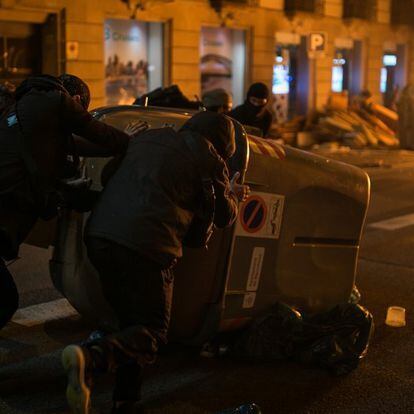 Un grupo de manifestantes mueve un contenedor de basura durante los altercados en el centro de b Barcelona.