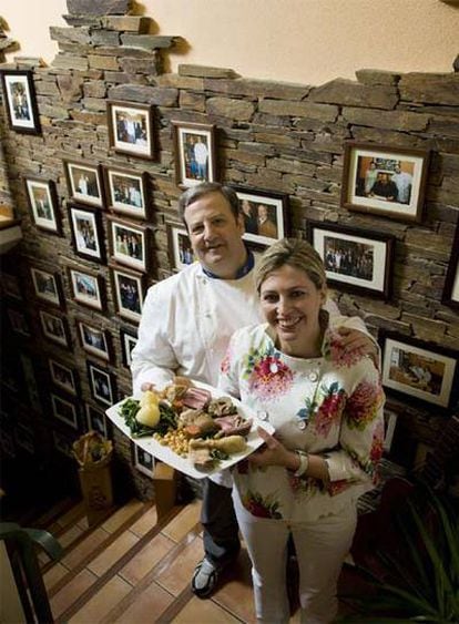 José Luis Iglesias y Áurea Vázquez, delante de la pared con fotografías de su restaurante.