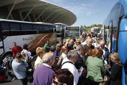 Autobuses fletados por las compañías aéreas recogen a viajeros afectados en el aeropuerto de Bilbao.