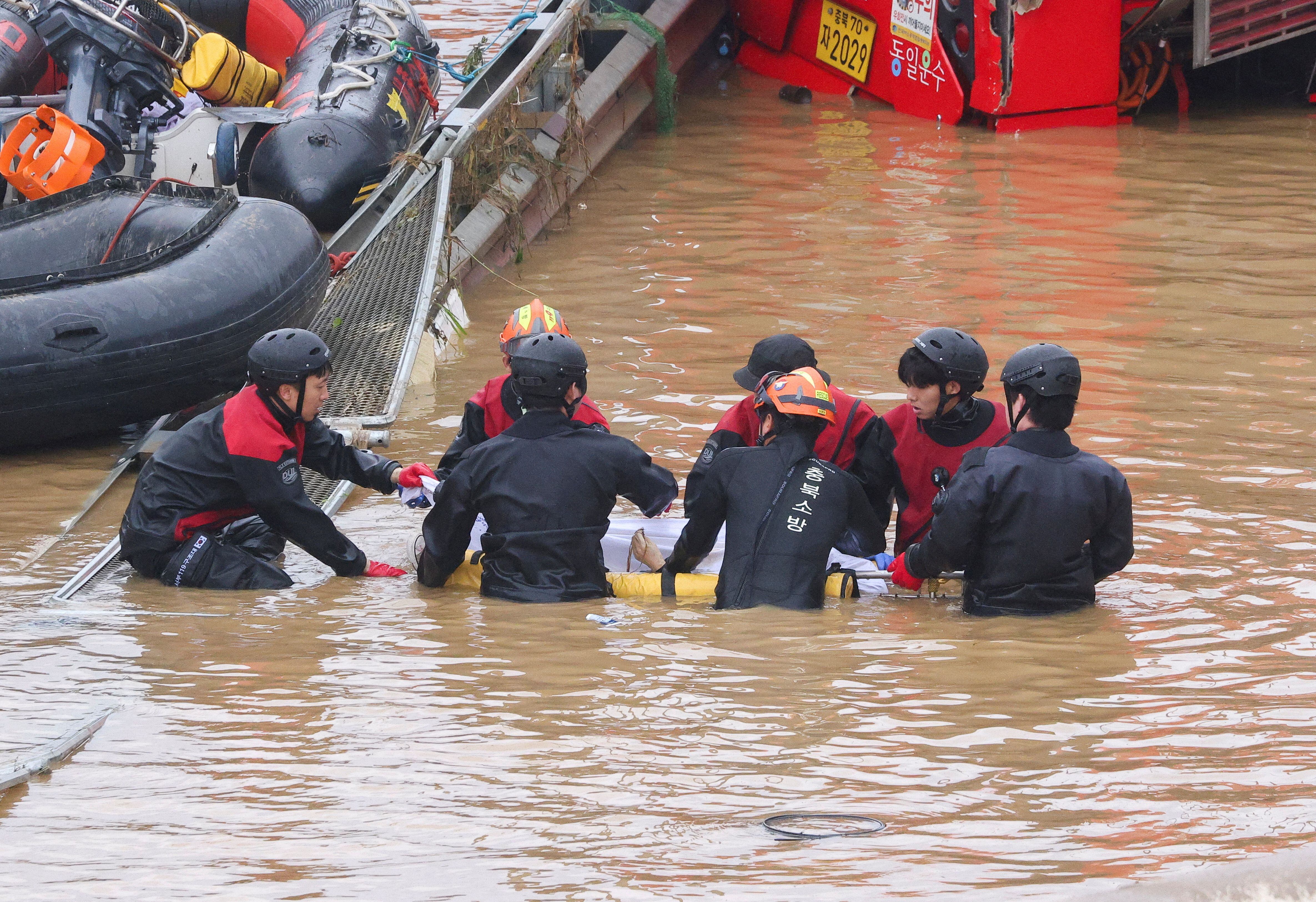Los equipos de rescate llevan el cuerpo de una víctima hallado durante las tareas de salvamento en busca de supervivientes de las inundaciones.